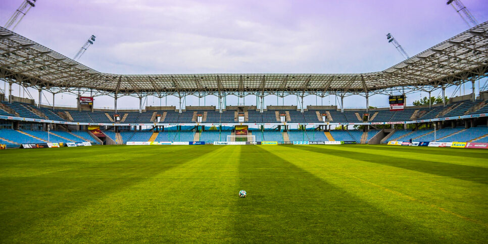 image of an empty soccer stadium with a lone ball in the middle