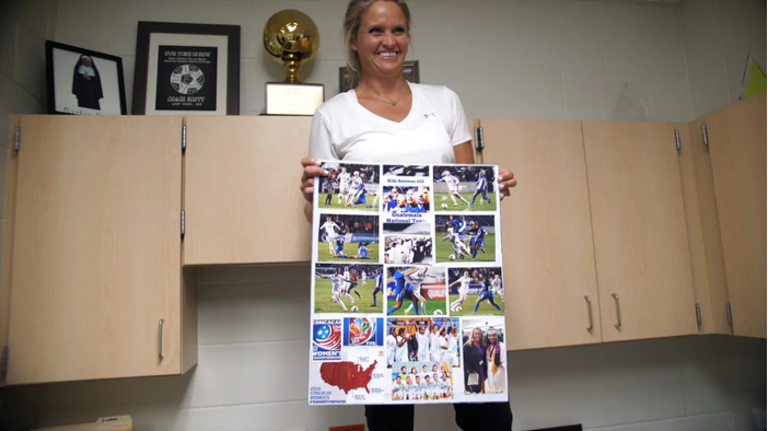 Photograph of Coach Scott sharing a picture board from a past player.