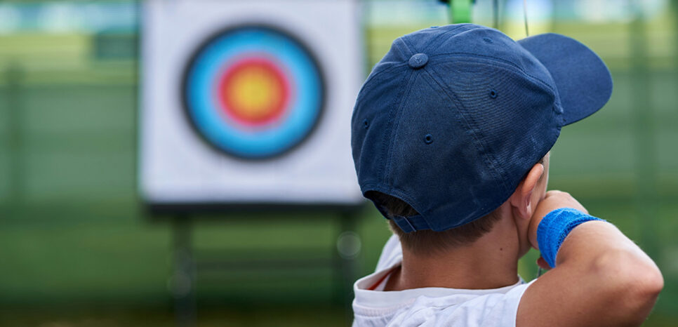 Photograph of kid shooting a bow and arrow